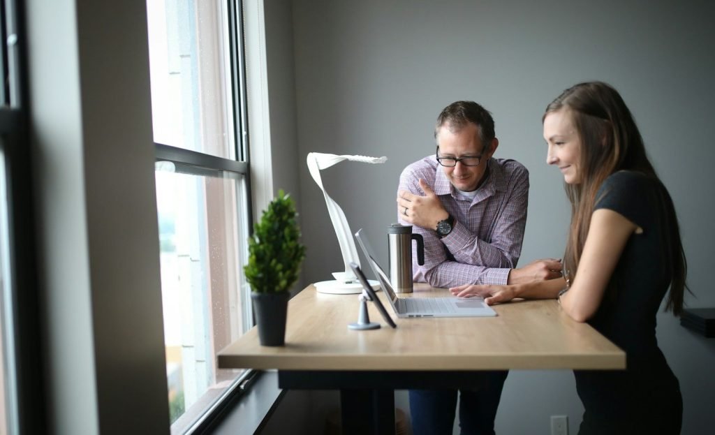 Mentor coaching a colleague at a desk