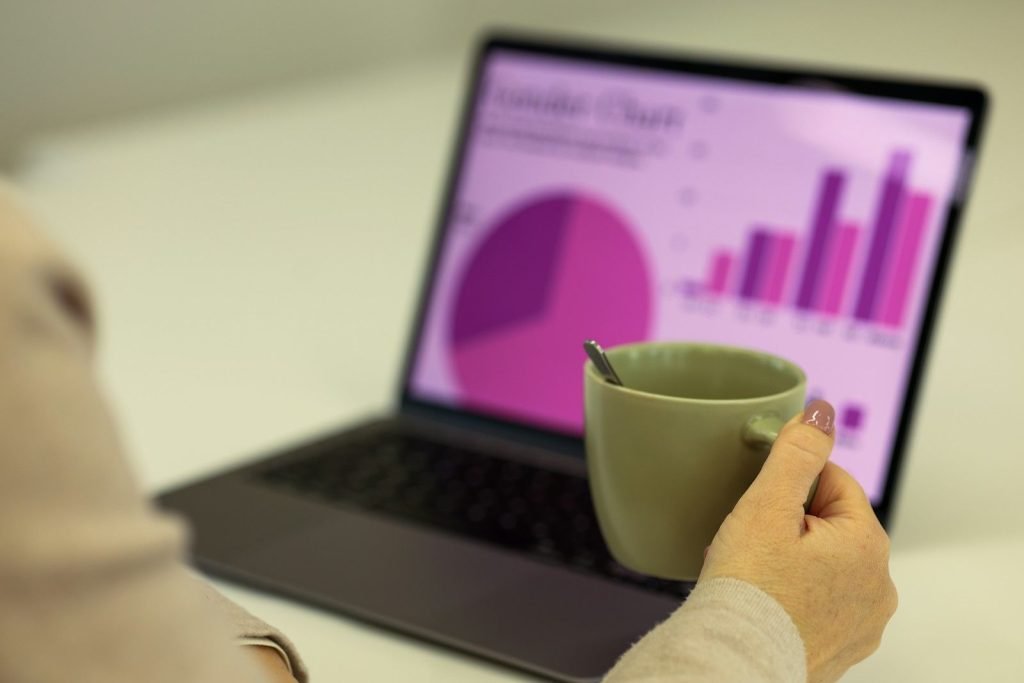 Reviewing charts on a laptop with coffee