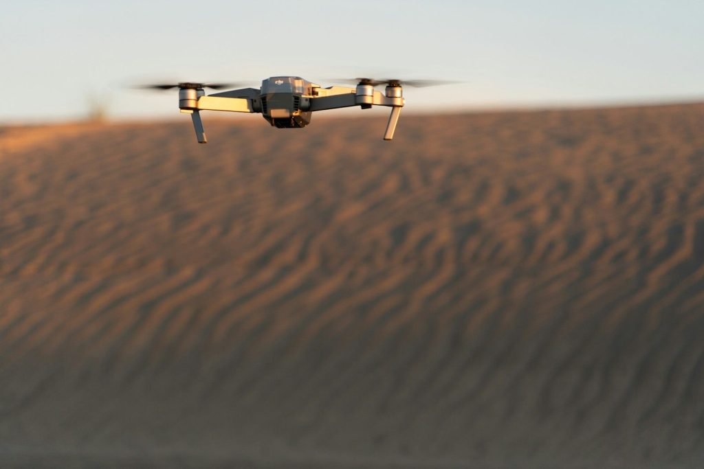 Camera drone flying over sand dunes